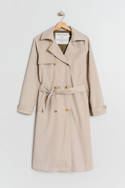 A timeless, double breasted Classic Button Down Trench Coat crafted with a lapel collar, long sleeved cuffs with button accents, and a 3/4 length. This garment features an adjustable belt, which offers versatility and allows you to wear it open or cinched