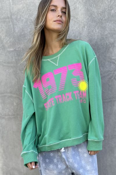 Retro style sweat in a new peachy feel fleece. The Sweatshirt has a Cotton stripe tape down the right sleeve with Soft bright print on the front. With Raw rib waistband and Wide body slouchy fit, it is shorter in the length than other sweats. With Contras