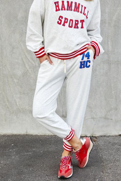 This sporty track pant captures an effortless retro varsity mood with a relaxed feel! 74 Retro sport track pant in oatmeal marle with HC 74 on the left hip for a sporty look. Contrast red and white rib elastic waist  an cuffs, draw cord and slouchy pocket