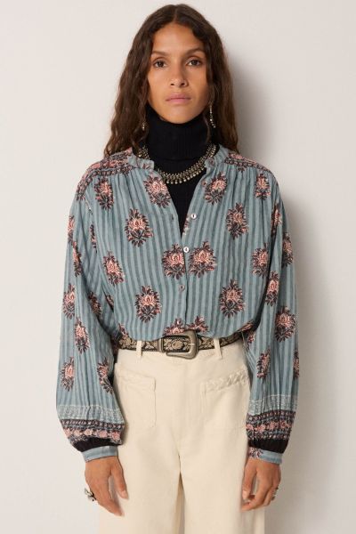 Cotton dobby with fine stripes, steady but soft to wear. The base carries depth, washed down like ceramic glaze. Printed floral medallions scatter across the blouse in reds and blues. Warm tones lift against cool ground, evoking age but with vibrancy.