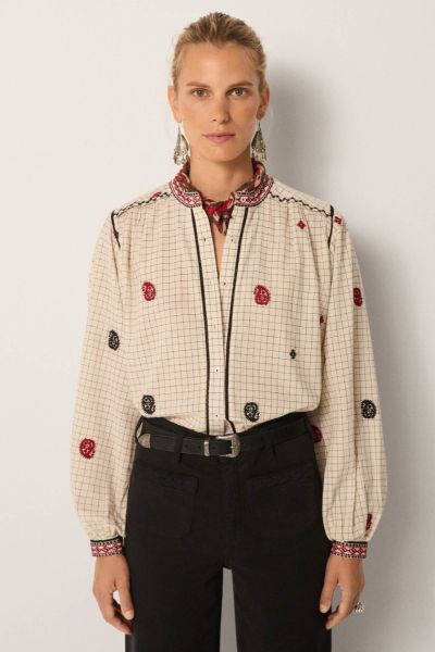 Soft cotton yarn dyed gives the blouse a subtle grid base with quiet texture. The ivory ground feels clean, timeless and versatile. Its surface is scattered with hand embroidered motifs in black and crimson, each carefully stitched. Borders at the collar 