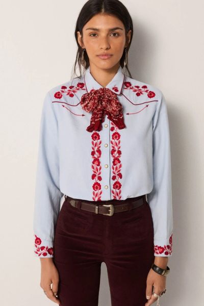A soft sky blue cotton lends this shirt a smooth, light texture, tailored into a modern cut that balances sharpness with ease.Striking red floral embroidery covers the chest, cuffs and button placket, while snap buttons underline its Western reference. Th