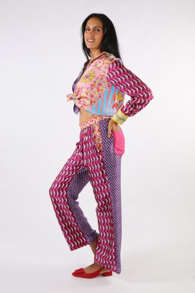 Elastic waist straight track pants in our Twisted Love print. Two side pockets, two back pockets. Front is a small pink geometric print. Waistbands are yellow, orange and purple little flowers. Back is a small purple geometric print. One back pocket is a 