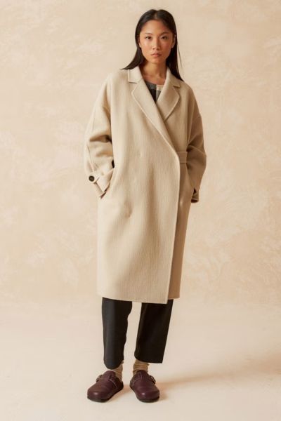 A classic yet updated coat, in a Japanese style with a crossover closure that ties on the inside with a ribbon and button, and a wide cut that sets it apart from others. Made of wool, it has a distinctive texture. style BY740.