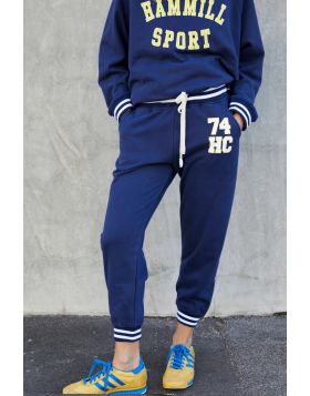 This sporty track pant captures an effortless retro varsity mood with a relaxed feel! 74 Retro sport track pant in soft navy with HC 74 on the left hip for a sporty look. Contrast navy and white rib elastic waist an cuffs, draw cord and slouchy pockets. M