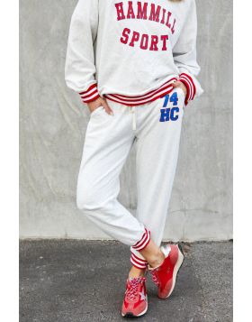 This sporty track pant captures an effortless retro varsity mood with a relaxed feel! 74 Retro sport track pant in oatmeal marle with HC 74 on the left hip for a sporty look. Contrast red and white rib elastic waist  an cuffs, draw cord and slouchy pocket