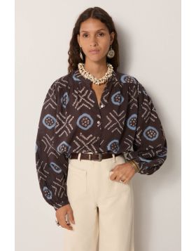 100% cotton voile blouse, cut loose with a soft drape, patterned in hand dyed geometrics. Circles framed in sky blue and dotted crosses run across a dark ground, the irregularity of each mark carrying the imperfect rhythm of craft. The voile is airy and t