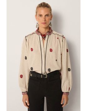 Soft cotton yarn dyed gives the blouse a subtle grid base with quiet texture. The ivory ground feels clean, timeless and versatile. Its surface is scattered with hand embroidered motifs in black and crimson, each carefully stitched. Borders at the collar 