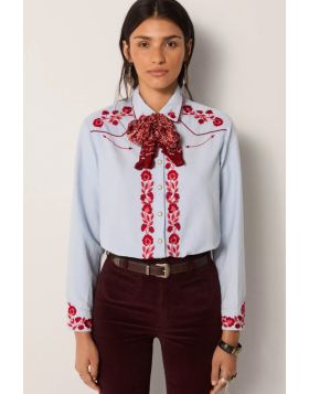 A soft sky blue cotton lends this shirt a smooth, light texture, tailored into a modern cut that balances sharpness with ease.Striking red floral embroidery covers the chest, cuffs and button placket, while snap buttons underline its Western reference. Th