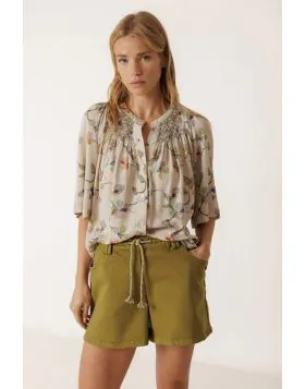 Shirt made from viscose fabric with a floral print. Sleeves with a bell shape, handmade smock detail on the yoke, and a buttoned front closure. AD102.
