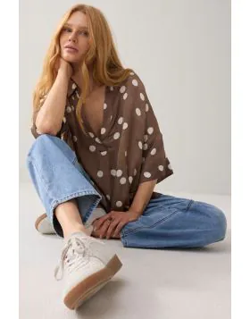 Top from soft Ecovero with a straight fit and straight, wide sleeves. The top has a polo neckline and a V-neckline with one button. Pair this polka dot top with the matching polka dot trousers. 2S3413.
