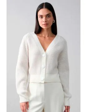 The Frankie Cardi is a modern take on a classic silhouette, featuring a deep V-neckline, oversized buttons, and a soft ribbed knit. Designed with a slightly cropped fit and wide ribbed cuffs, it offers a refined yet relaxed feel. Perfect for layering over