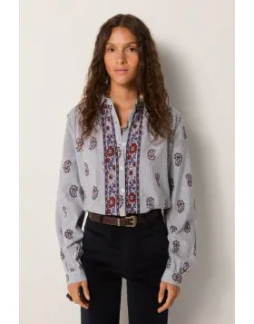 Soft cotton with a light hand forms the base of this blouse, striped in fine lines that carry subtle texture. Its relaxed fit feels effortless. The front placket is richly embroidered with panels in warm reds and indigos, while delicate gathers at the sho