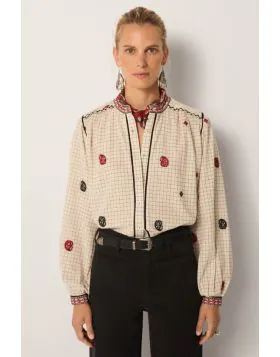 Soft cotton yarn dyed gives the blouse a subtle grid base with quiet texture. The ivory ground feels clean, timeless and versatile. Its surface is scattered with hand embroidered motifs in black and crimson, each carefully stitched. Borders at the collar 