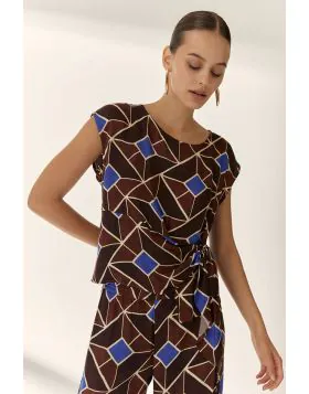 Sleeveless blouse with a round neck, made from a soft draping printed fabric. Features a side panel with a gathered detail and tie effect, adding a distinctive and feminine touch. Regular fit.V26230.
