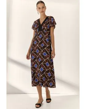 The Paz Torras Printed Dress features a V neck design and flutter sleeves, providing a balanced combination of comfort and style. Its full length cut offers extended coverage suitable for various settings, enhancing versatility in wardrobe options. Geomet