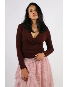 This wrap front sweater top features a chic, elegant design with a natural V neck that flatters effortlessly. Crafted from a stretchy fabric blend in a soft sweater knit, it offers both comfort and style. Pair it with the matching knit skirt for a refined