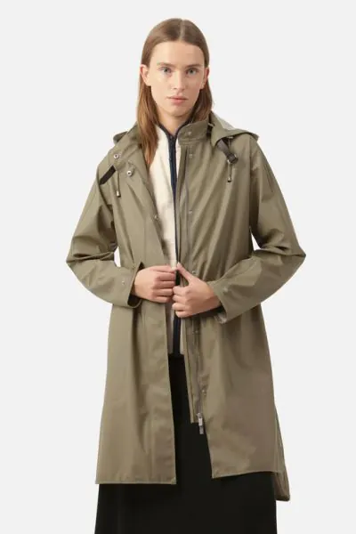 A feminine A shaped under knee raincoat in loose fit. The hood is detachable and is attached by a weather proof strap in artificial leather. The style features side pockets with flaps, fancy slits in side seams with press buttons, button closure at wrist 