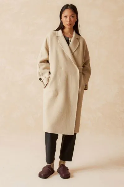 A classic yet updated coat, in a Japanese style with a crossover closure that ties on the inside with a ribbon and button, and a wide cut that sets it apart from others. Made of wool, it has a distinctive texture. style BY740.