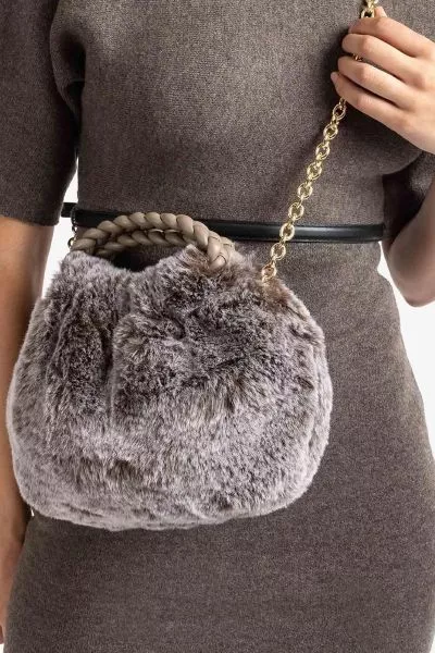 The UNISA ZBEN is a stylish faux fur clutch bag featuring a taupe colour blend. It offers versatility with a hand strap and a detachable chain, allowing it to be carried by hand or worn over the shoulder. Secured with a magnetic snap closure, this bag is 