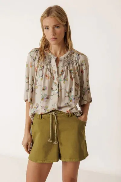 Shirt made from viscose fabric with a floral print. Sleeves with a bell shape, handmade smock detail on the yoke, and a buttoned front closure. AD102.

