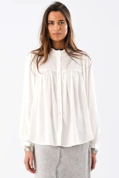 The Cara shirt is a testament to sophisticated design and meticulous craftsmanship. This charming piece boasts a voluminous silhouette that effortlessly marries classic elegance with modern flair. The shirt features long sleeves, a refined round, ruffled 