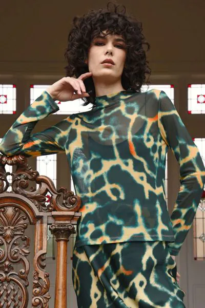 Soft stretch mesh creates a fluid, second skin feel in the DONT GET MESHY Top. Crafted in SEA CHANGE printed mesh, this piece features a mock neck and a lightweight finish that moves effortlessly with the body and layers like a dream.CT257413B.
