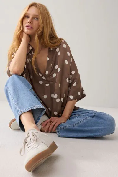 Top from soft Ecovero with a straight fit and straight, wide sleeves. The top has a polo neckline and a V-neckline with one button. Pair this polka dot top with the matching polka dot trousers. 2S3413.
