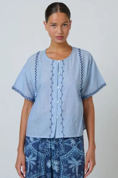The Elodie Top is an easy, feminine style with beautiful embroidered detailing throughout. Crafted from lightweight cotton, it features a relaxed boxy shape, button through front and softly gathered back for an effortless everyday fit. DE35.

