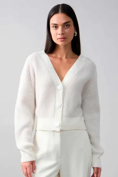 The Frankie Cardi is a modern take on a classic silhouette, featuring a deep V-neckline, oversized buttons, and a soft ribbed knit. Designed with a slightly cropped fit and wide ribbed cuffs, it offers a refined yet relaxed feel. Perfect for layering over