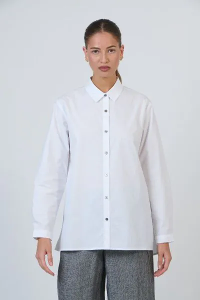 GA665 brings new dimension to the classic button down. Crafted from 100% poplin, it features a sharp pointed collar and full button placket that accentuates its modern form. The oversized, boxy silhouette drapes effortlessly with a slightly extended back 