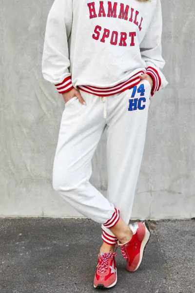This sporty track pant captures an effortless retro varsity mood with a relaxed feel! 74 Retro sport track pant in oatmeal marle with HC 74 on the left hip for a sporty look. Contrast red and white rib elastic waist  an cuffs, draw cord and slouchy pocket