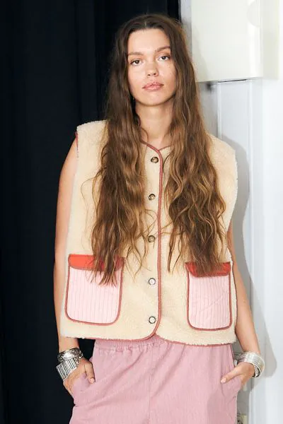 Beautiful and lovely beige jace fleece vest from Lollys Laundry. It has a round neckline and a nice button closure at the front. It has no sleeves and 2 decorative pockets at the front. On the back it has its statement appliqued design that turns heads fo