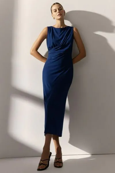 Midi dress in stretch knit with a boat neckline that accentuates the shoulders and adds a sophisticated touch. Its sleeveless design and side draping flatter your figure. A very versatile garment, ideal for special occasions as well as everyday wear. Regu