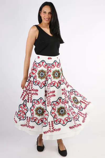 Pearl and Caviars Samarina embroidered skirt blends Greek tradition with modern style, featuring vibrant folk motifs and a flowing, tiered cut in breathable cotton. A luxurious Greek inspired maxi skirt featuring bold folkloric patterns, crafted in breath