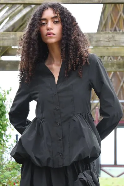 A playful sense of structure defines the silhouette. The PEPLUM PLAY Top is statement femininity with a modern edge. Crafted in SWISH YOU WERE HERE taffeta, this piece features a flattering V neckline and button through front, balanced by a voluminous bag