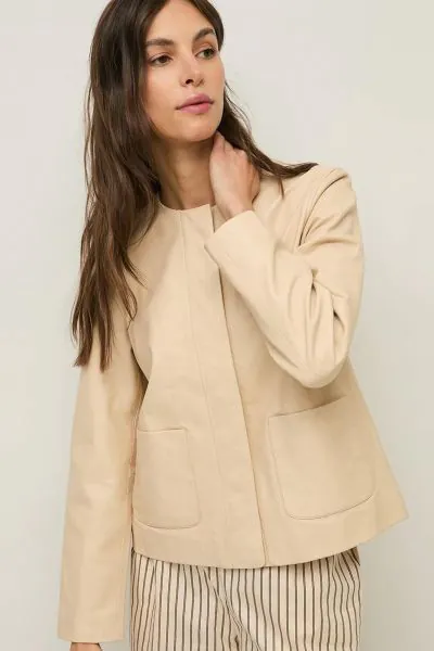 Sleek, understated and easy to style, the Yerse 44809 Ecru Cream Collarless Leather Jacket is the kind of layer that instantly pulls a look together. In a soft ecru cream leather jacket, this clean lined style features a modern collarless neckline, concea