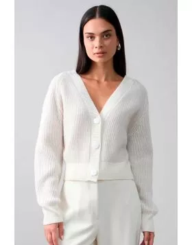 The Frankie Cardi is a modern take on a classic silhouette, featuring a deep V-neckline, oversized buttons, and a soft ribbed knit. Designed with a slightly cropped fit and wide ribbed cuffs, it offers a refined yet relaxed feel. Perfect for layering over