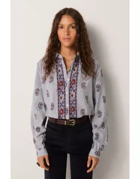 Soft cotton with a light hand forms the base of this blouse, striped in fine lines that carry subtle texture. Its relaxed fit feels effortless. The front placket is richly embroidered with panels in warm reds and indigos, while delicate gathers at the sho