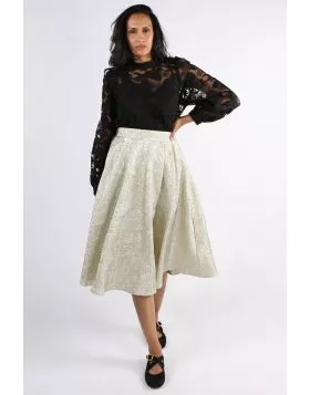 A champagne colored midi skirt made from high-quality, textured material with a crinkle and metallic finish. The skirt flows softly with every step, adding an elegant lightness to your look. The flowing A line silhouette and sophisticated surface make it 